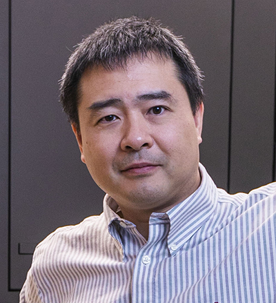 Headshot of Teru Nakagawa wearing a blue-and-white vertical stripe shirt.