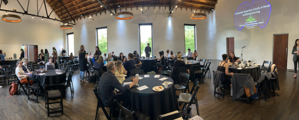 Participants sitting at tables and mingling at VCAR Science Day