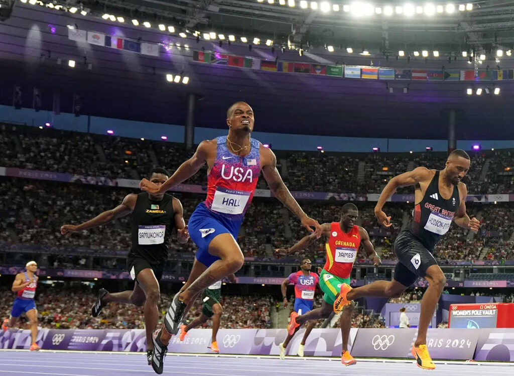 Quincy Hall crossing the finish line ahead of his competitors.