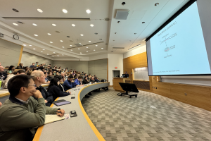 Photo of attendees watching seminar presentation.