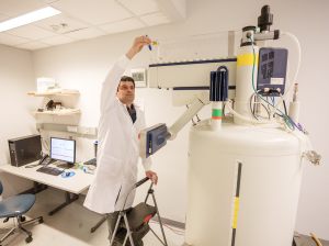 Photo of lab technician placing sample in NMR instrument. Photo: Harrison McClary/Vanderbilt University