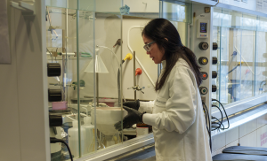 Photo of lab technician in front of lab hood. Photo: Harrison McClary/Vanderbilt University