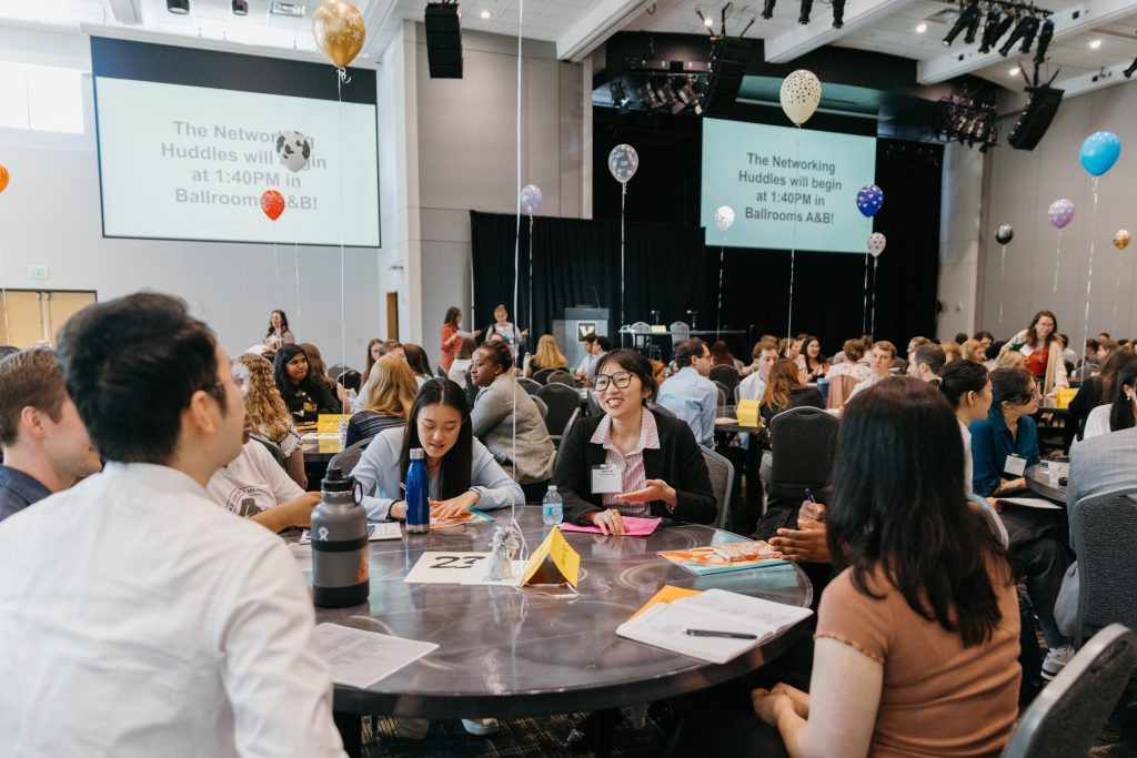 Career symposium attendees socializing around tables.