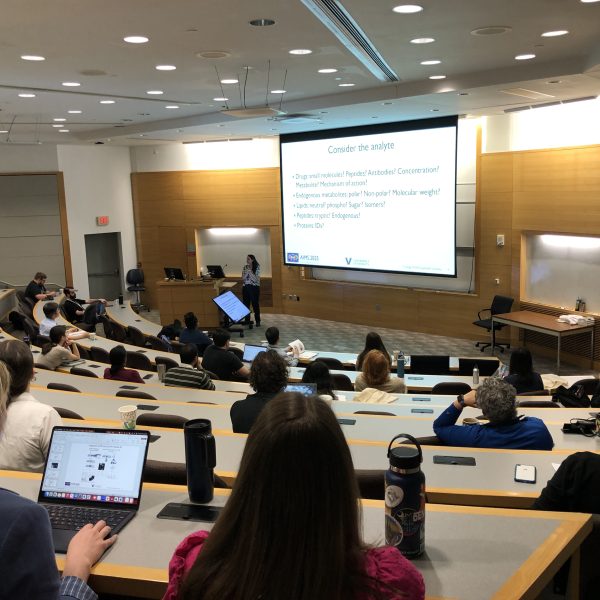 Attendees at symposium in a large lecture room.