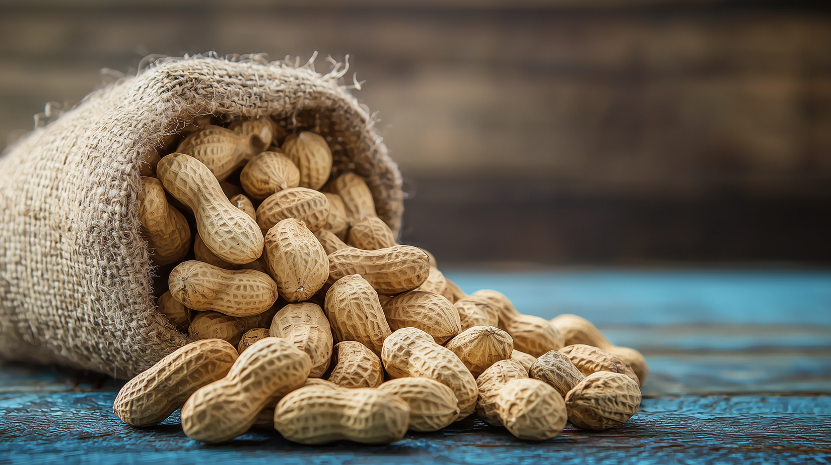 Closeup of raw peanuts in their shells on a wooden table with a natural, organic look. Adobe Stock image by Ivrin Generated with AI.