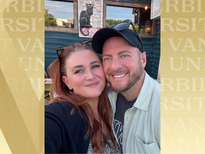 David Stiles (right) and wife, with gold VU background