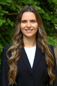 Headshot of student wearing blue dress jacket and white top