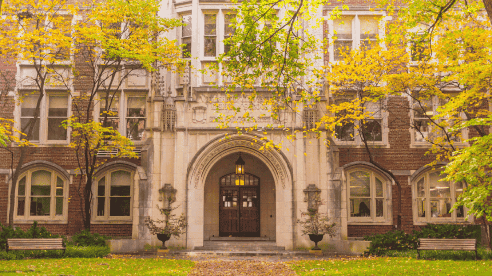 A set of historic wooden double doors, framed by a stone archway in a historic building.