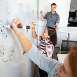 VUSM students drawing diagrams on a whiteboard.