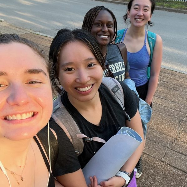 Four yoga students smile