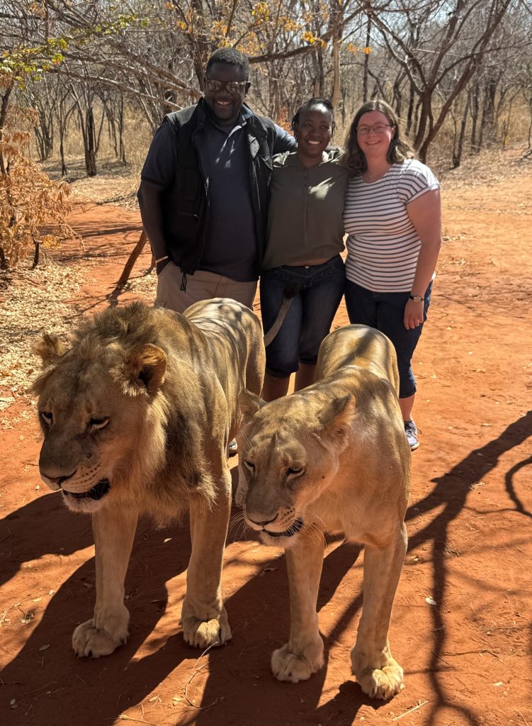 Mwanza, his wife, and Frenia, meet lions at a conservation organization in Livingstone, Zambia.