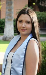 A woman wears a graduate stole