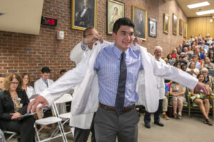 A man puts on a white coat