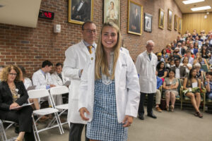 A woman puts on a white coat