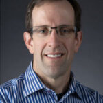 Man in glasses and a blue and white striped shirt