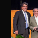 Bartels holding the Earl Sutherland Prize with Chancellor Zeppos to his right with a hand on Bartels' shoulder