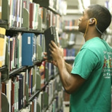 student checking out books in library