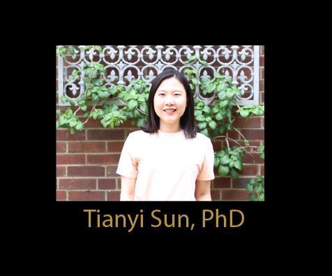 Chinese woman in pastel yellow shirt standing in front of brick wall, white ironwork planter with leafy green vines