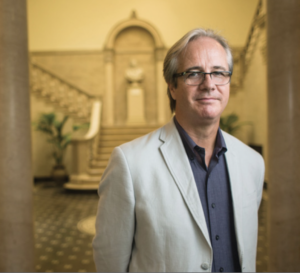 Image of Kevin Murphy. Subject is wearing professional dress and is standing between two pillars.