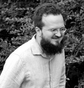 Headshot of David Michelson shot in black and white. Subject is standing in front of a tree.