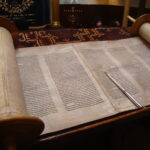 A picture of an unrolled scrolled with handwritten text