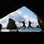 Students jumping in cave tunnel while abroad