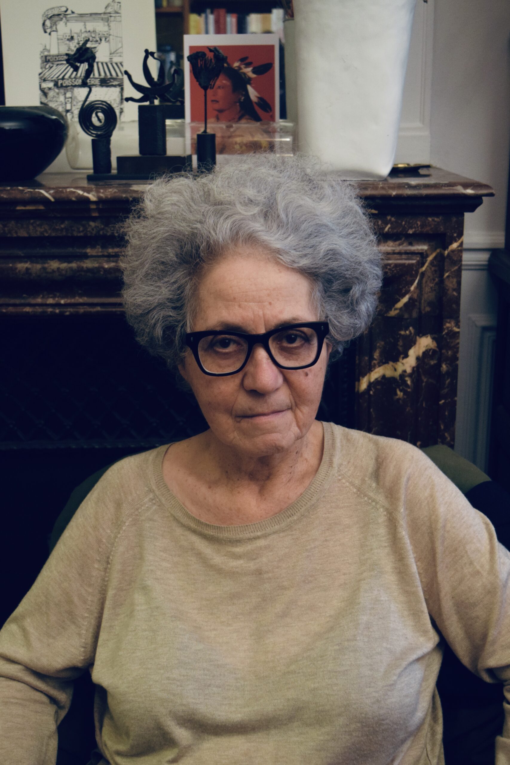 Three-quarter frame portrait of woman with gray hair and black-framed glasses