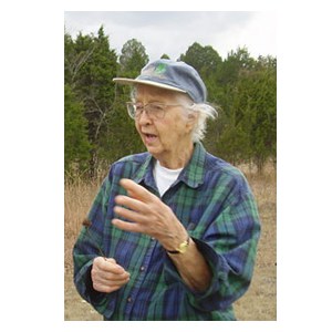 Elsie in the field talking about plant conservation wearing a blue and green plaid shirt. Circa 2000