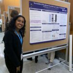 Charu standing in front of her research poster