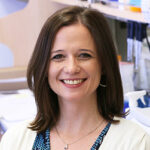 Emily Hodges in a lab coat smiling