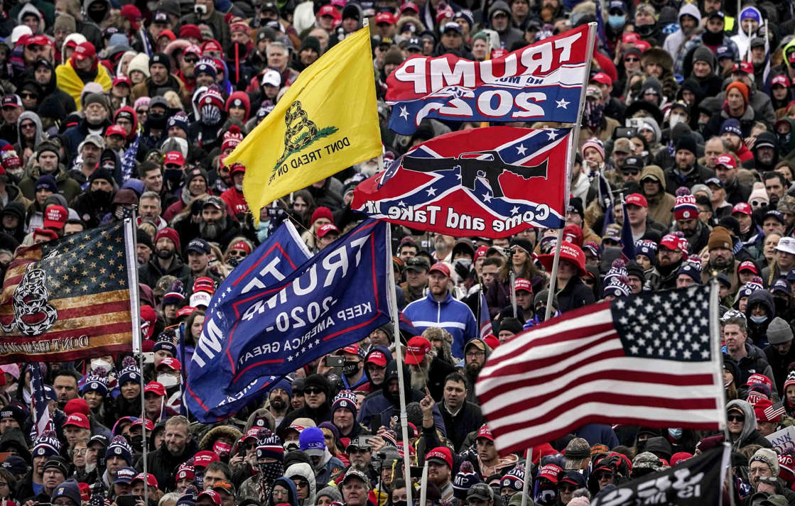 Supporters of President Donald Trump, with a Confederate-themed flag among others, listen to him speak as they rally in Washington before the deadly attack on the U.S. Capitol on Jan. 6.