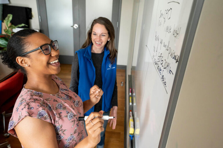 woman writing on whiteboard