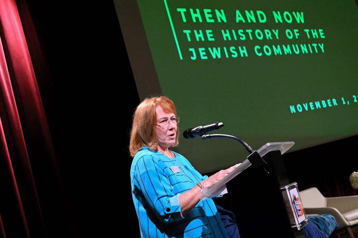 Lynn Fleischer on stage addressing a crowd at the Nashville Public Library