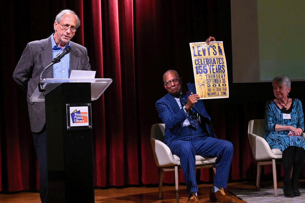 Ralph Levy Jr. on stage addressing a crowd at the Nashville Public Library