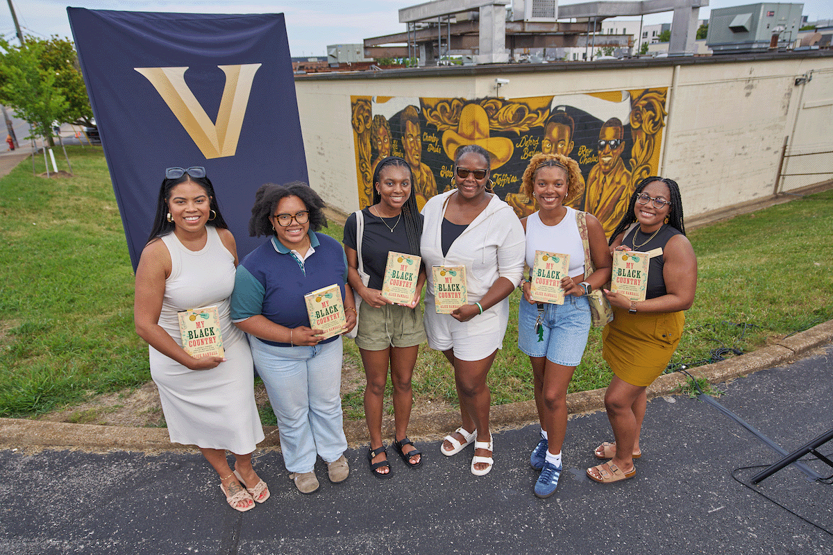 Group photo of event attendees holding copies of the book 