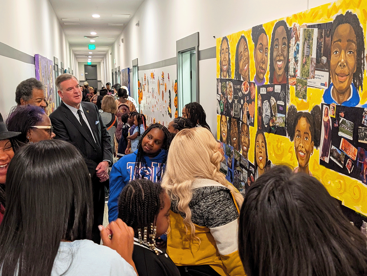 Students, community members and Vanderbilt Vice Chancellor Nathan Green admire the newly unveiled mural panels at Salama Urban Ministries.