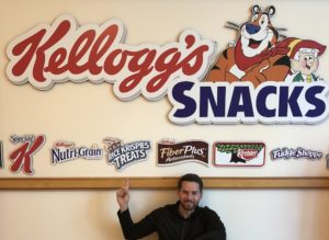 Brandon Kieffer (Vanderbilt MBA'19) poses beneath a wall full of Kellogg's Snacks logos