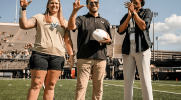 Pictured from Left to Right: Sarah Marvin, Mario Avila, and Candace Storey Lee. Marvin and Avila hold up the "VU" hand sign that is popular to show Vanderbilt pride. Lee is clapping.
