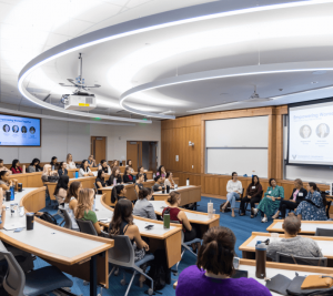 Pictured: a wide shot of the classroom. Every seat in the classroom is occupied. Panelists sit in a row facing the Vanderbilt Business attendees for the Women’s Leadership Summit.