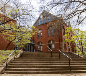 Pictured: An image of the exterior of Management Hall. This photo is taken from the bottom of the stairs near the school entrance closest to Vanderbilt's Law School. The photo was taken during autumn, and the trees that frame the building are sparse.