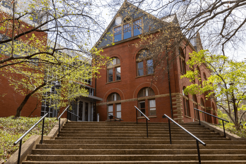 Pictured: An image of the exterior of Management Hall. This photo is taken from the bottom of the stairs near the school entrance closest to Vanderbilt's Law School. The photo was taken during autumn, and the trees that frame the building are sparse.