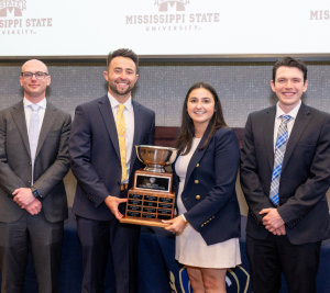 Pictured: Posing with the trophy, the winning team of the 2024 SEC MBA Case Competitionis shown. From left to right: Robert Rickard, Andrew Winter, Monica Traniello, and Zachary Terry.