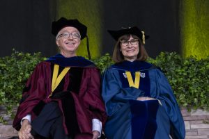 Pictured: Vanderbilt Business' Richard H. Willis and Jennifer Edson Escalas from left to right. Willis and Escalas are sitting on stage at the 2024 Commencement.