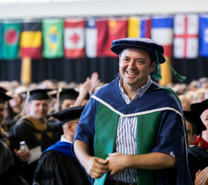 Pictured: Mumin Kurtulus standing and smiling after his name was called in recognition of the Executive MBA Faculty Teaching Award.