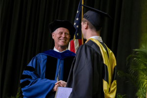 Dean Steenburgh at Commencement 2024 shaking a graduate's hand