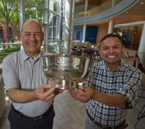 Pictured: Lapré and Gonzales smile while holding the Chancellor's Cup in the lobby of Vanderbilt Business. Photo by Vanderbilt University.