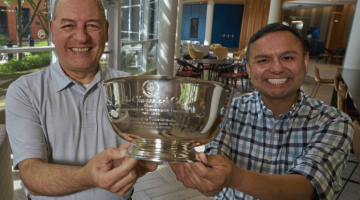 Pictured: Lapré and Gonzales smile while holding the Chancellor's Cup in the lobby of Vanderbilt Business. Photo by Vanderbilt University.