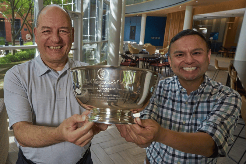 Pictured: Lapré and Gonzales smile while holding the Chancellor's Cup in the lobby of Vanderbilt Business. Photo by Vanderbilt University.