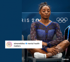 Pictured: A screenshot from Simone Biles' Instagram account. Biles is sitting in a chair with her eyes closed at the 2024 Paris Olympics. Biles appears to be meditating. Layered on the image is the Instagram caption that Biles posted "Mental Health Matters".