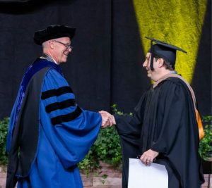 Pictured: Ralph Owen Dean Tom Steenburgh shakes hands with 2025 Vanderbilt Business Commencement Speaker Jeremy Padawer